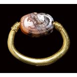 A Greek archaic agate scarab seal set in a swivel gold ring. Griffin.