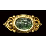A roman green chalcedony intaglio set in a gold ring. Heafer under a tree.2nd century A.D.