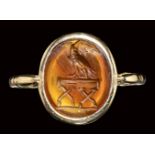 A roman carnelian intaglio mounted on a modern gold ring. Eagle on a stand. 2nd century A.D.