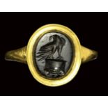 A roman obsidian intaglio mounted on a modern gold ring. Eagle on altar. 2nd