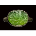 A Late Roman - Early Christian green glass intaglio, set in a silver ring. Busts of a man, woman and