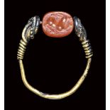 A small etruscan carnelian scarab mounted in a gold ring. Antelope.