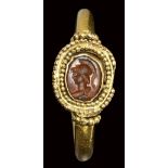 A roman carnelian intaglio set in an ancient gold ring. Bust of Athena. 3rd century A.D.