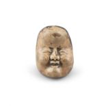 A WOOD NETSUKE OF OKAME Japan, 19th century Shaped as a face of Okame, the back inscribed with a