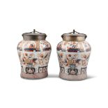 A PAIR OF JAPANESE IMARI PORCELAIN URNS, with bronze collar and lids above circular baluster bodies,