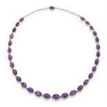 A LATE VICTORIAN AMETHYST RIVIÈRE NECKLACE, CIRCA 1900 The graduated oval-shaped amethysts,