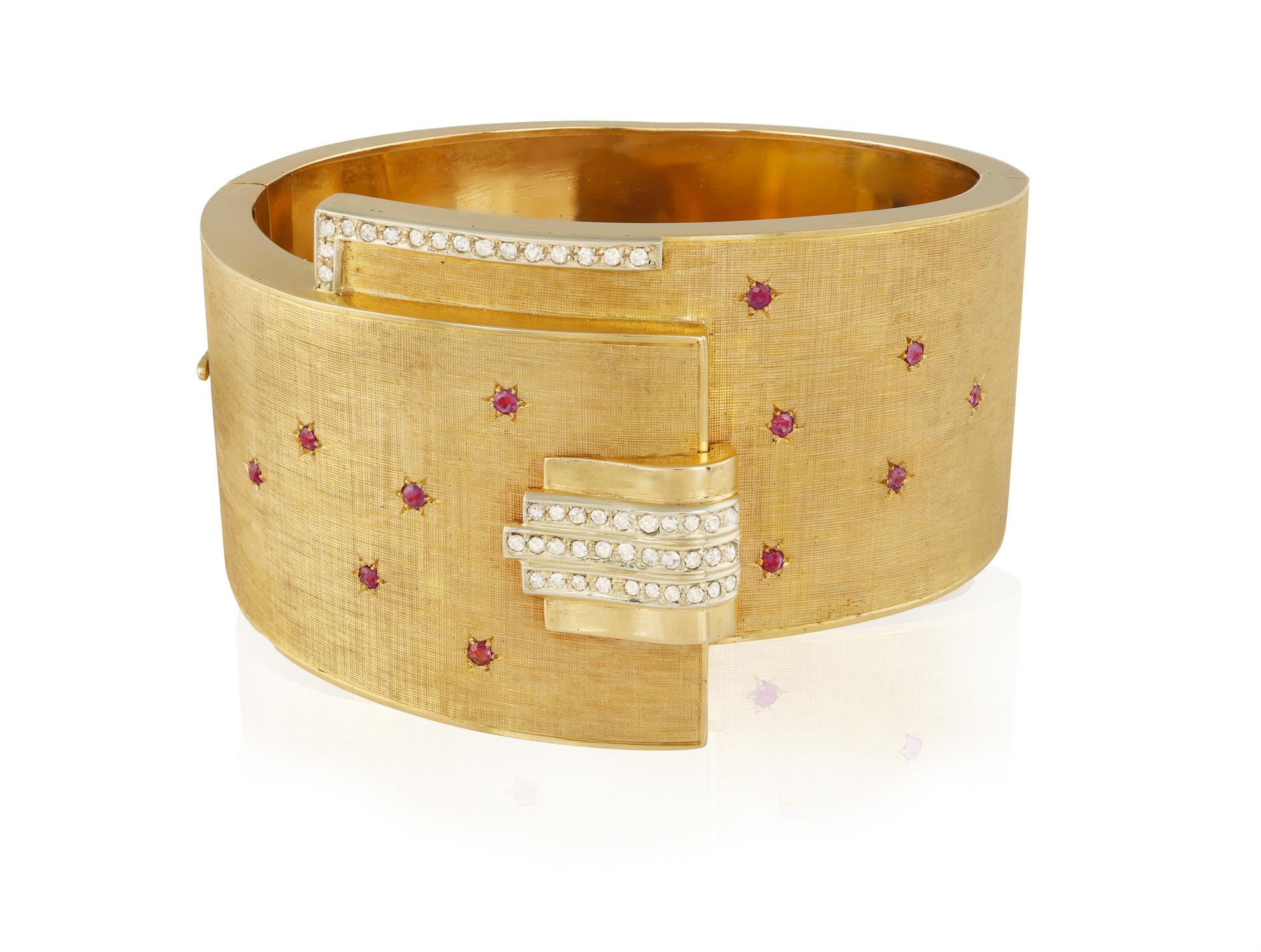 A RETRO RUBY AND DIAMOND BANGLE, CIRCA 1945 The hinged textured bangle highlighted with