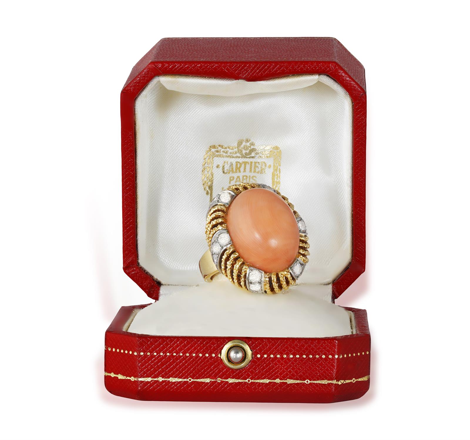 A CORAL AND DIAMOND COCKTAIL RING, BY CARTIER, CIRCA 1955 The oval-shaped corallium rubrum