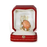 A CORAL AND DIAMOND COCKTAIL RING, BY CARTIER, CIRCA 1955 The oval-shaped corallium rubrum