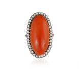 A CORAL AND DIAMOND COCKTAIL RING, CIRCA 1950 Composed of a large elongated oval-shaped