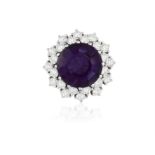 AN AMETHYST AND DIAMOND CLUSTER RING The circular mixed-cut amethyst weighing approximately 6.