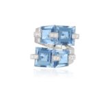 A BLUE TOPAZ AND DIAMOND COCKTAIL RING BY LEGNAZZI, of crossover design set with four square and