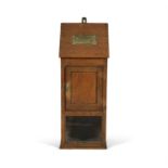 AN EDWARDIAN OAK AND BRASS MOUNTED POST CABINET, the slopefront top with recessed letter insert,