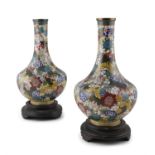 A PAIR OF CLOISONNE VASES, c.1900, of baluster shape, decorated with flowers, on circular hardwood