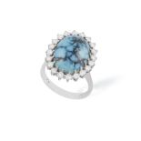 A TURQUOISE AND DIAMOND CLUSTER RING, composed of an oval-shaped turquoise cabochon within a