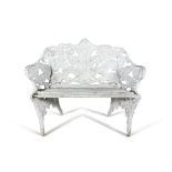 A WHITE PAINTED CAST IRON GARDEN SEAT, of compact two-seater proportion with fern pattern back and