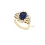 A SAPPHIRE AND DIAMOND CLUSTER RING, the central oval-shaped sapphire weighing approximately 2.