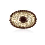 A GARNET BROOCH, centrally set with an oval-shaped garnet within a four-claw setting,