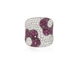 A RUBY AND DIAMOND COCKTAIL RING, of concave design, embellished with two flower motifs pave-set
