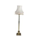 A BRASS FLUTED STANDARD LAMP, with cream shade, on stepped square base. 132cm high