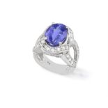 A TANZANITE AND DIAMOND DRESS RING, the central oval-shaped tanzanite weighing approx. 3.70cts,