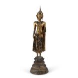 A MONUMENTAL GILT LACQUERED BRONZE FIGURE OF A STANDING BUDDHA Northern Thailand, 19th century
