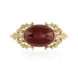 A GARNET AND GOLD BROOCH, the central oval faceted garnet within a foliate gold frame, in 14K gold,