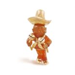 A CARVED AGATE AND GOLD NOVELTY PENDANT, CIRCA 1960 The carved agate mariachi player with gold