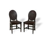 A PAIR OF IRISH MAHOGANY HALL CHAIRS, c.1790, the oval solid backs with central oval medallions,