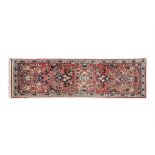 A NAHAVAND RED GROUND RUNNER, Iran, the central reserve woven with floral and foliate decoration in