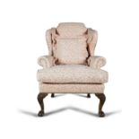 A GEORGIAN STYLE MAHOGANY FRAMED UPHOLSTERED WINGBACK ARMCHAIR COVERED IN LEAF PATTERN MATERIAL,