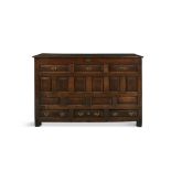 A LATE 18TH CENTURY STAINED OAK RECTANGULAR CHEST, with lift top above a false drawer and fielded