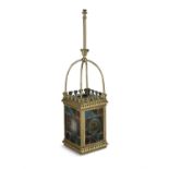 A LARGE EDWARDIAN BRASS AND STAINED GLASS HALL LANTERN, each of the four glass panels fitted with