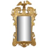 AN ECCENTRIC IRISH GEORGE III CARVED GILTWOOD MIRROR, c.1740 with tall scroll shoulders,