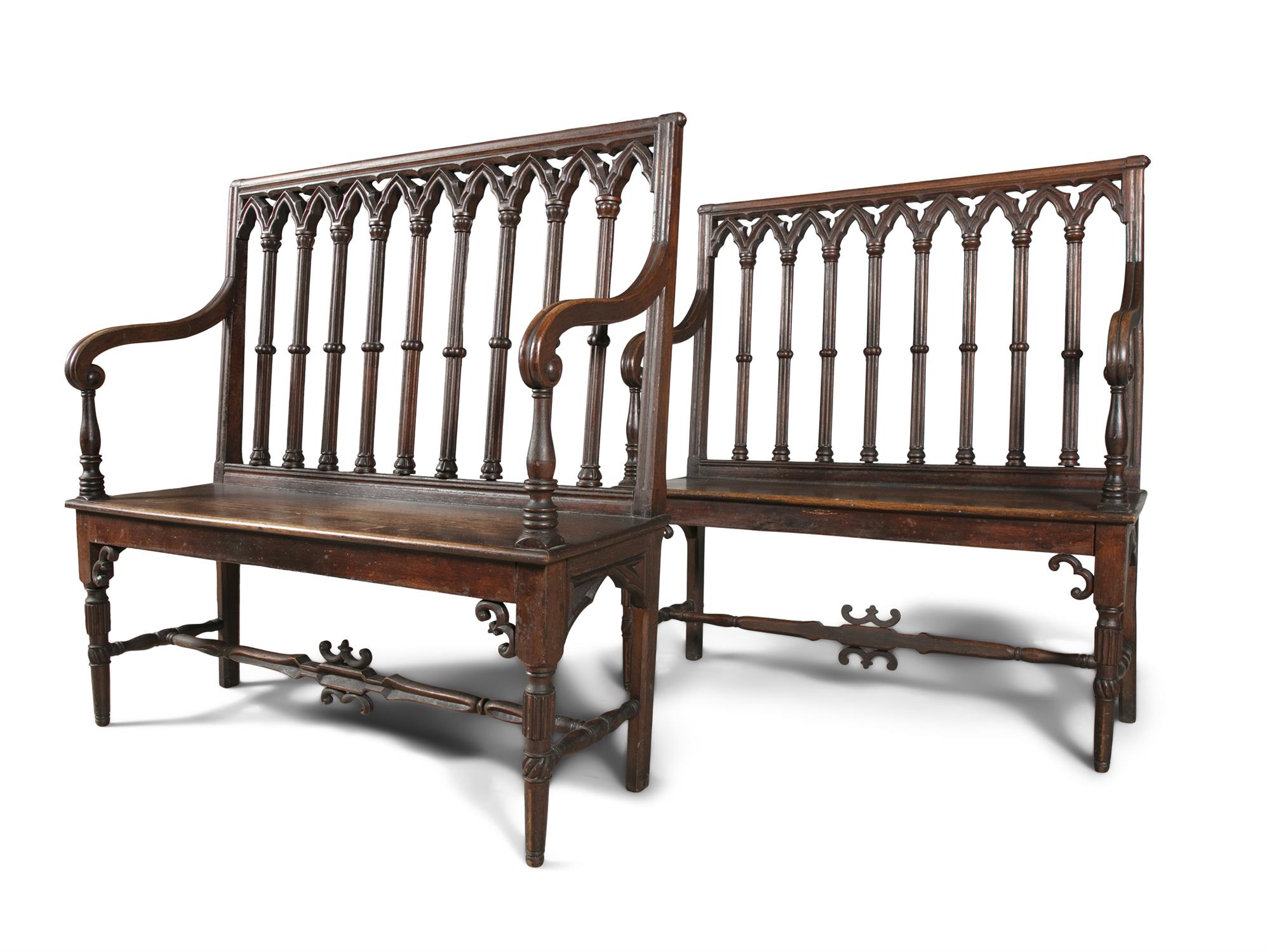 A MATCHED PAIR OF 19TH CENTURY CARVED OAK BENCHES, in the Gothic style, the arched gallery backs