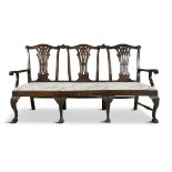 AN IRISH 18TH CENTURY MAHOGANY TRIPLE CHAIR BACK SETTEE, the arched crest rail decorated with