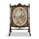 A LARGE VICTORIAN WALNUT FRAMED TAPESTRY FIRE SCREEN, the oval needle work panel enclosed within