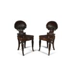 A PAIR OF GEORGE IV MAHOGANY HALL CHAIRS, in the manner of Gibton with well carved scallop shell