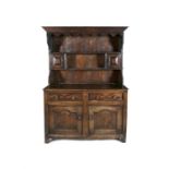 A 19TH CENTURY STAINED OAK WELSH DRESSER, with moulded cornice above open shelves and two small