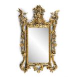 AN IRISH CARVED GILTWOOD ARMORIAL MIRROR, the tall cresting with a floral basket,