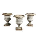 THREE WHITE PAINTED CAST IRON GARDEN URNS, each of campagna form with out turned egg and dart