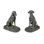 A PAIR OF LARGE CAST IRON MODELS OF SEATED HOUNDS, one with game at its feet, the other with a