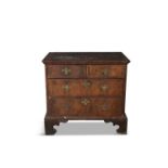 A GEORGE II COMPACT WALNUT CHEST OF DRAWERS, the rectangular crossbanded top with moulded rim,