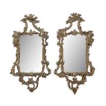 A PAIR OF GEORGE III CARVED GILTWOOD WALL MIRRORS, the rectangular plates within asymmetrical