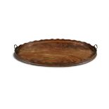 A 19TH CENTURY MAHOGANY OVAL TRAY with raised scallop rim and brass side carrying handles.