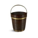 A GEORGE III MAHOGANY BRASS BOUND FUEL BUCKET of ribbed coopered construction with brass swing