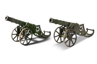 A PAIR OF 19TH CENTURY CAST IRON SIGNAL CANNONS, each on two wheel carriages. 155cm long,
