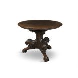 A CARVED OAK CIRCULAR CENTRE TABLE, 19th Century, the solid panel top with carved edge on triform