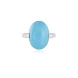 A TURQUOISE AND DIAMOND DRESS RING The central oval-shaped turquoise cabochon within a