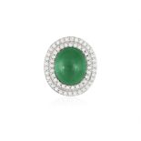 AN EMERALD AND DIAMOND DRESS RING The central oval-shaped emerald cabochon weighing